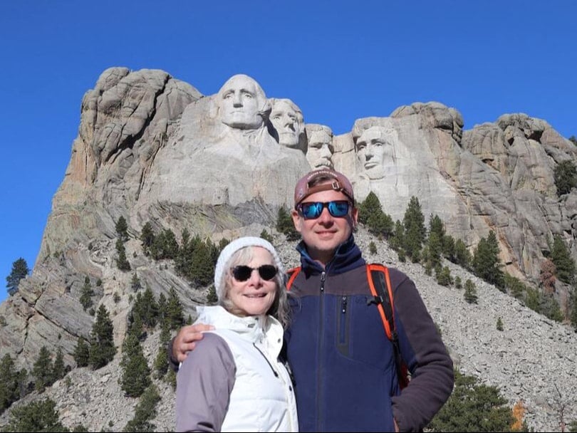 owner of my xo adventures, daniel milks with his mom at mount rushmore national memorial