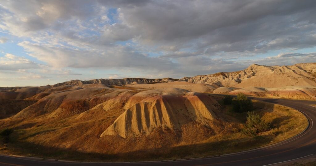 badlands yellow mounds golden hour road curving