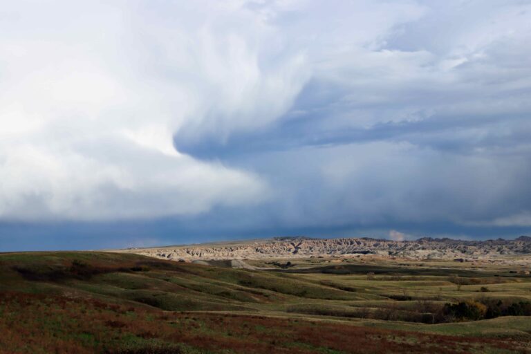 large clouds forming over the badlands changing the light and shadow of the land.