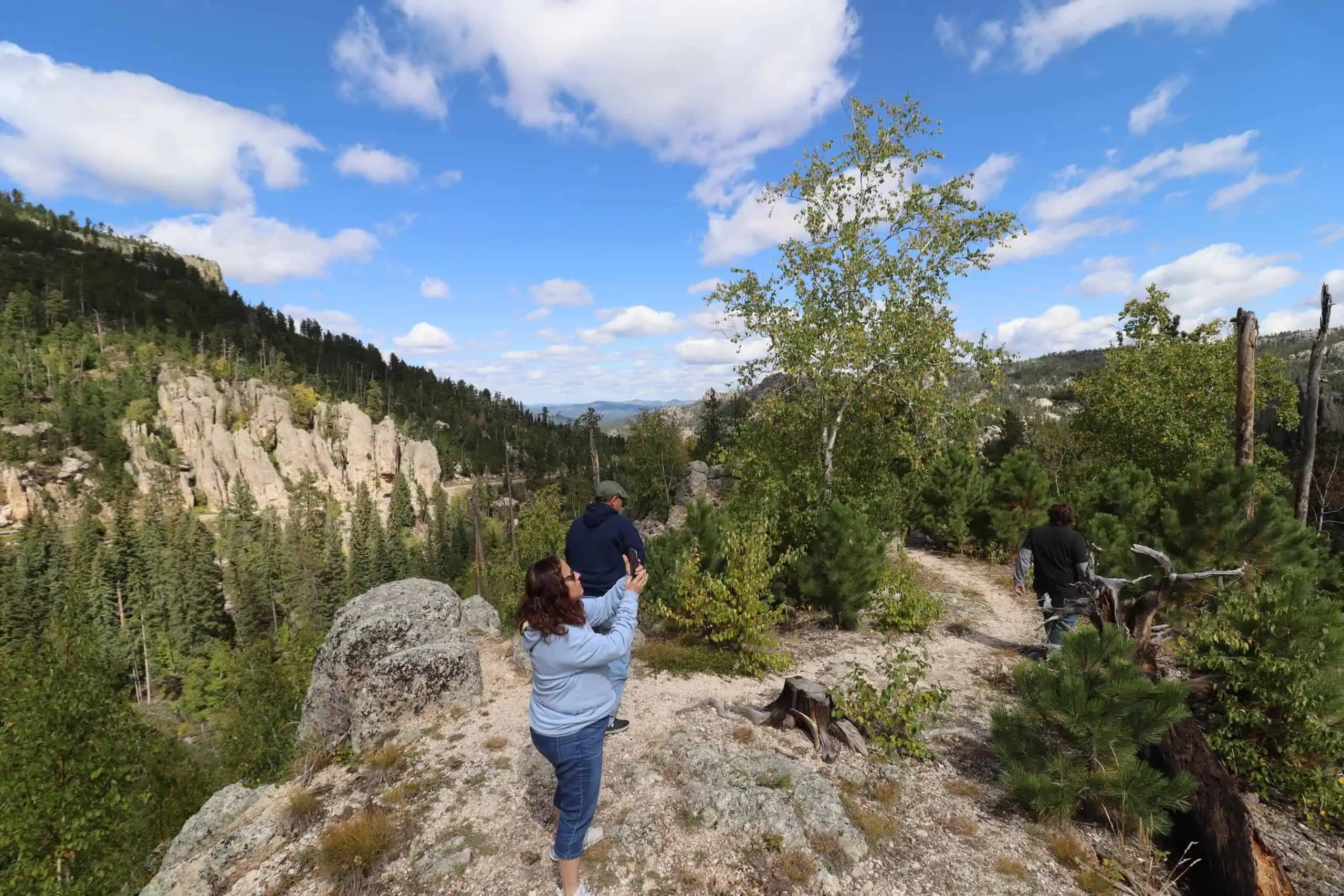 hikers on a rocky outcrop above spearfish canyon